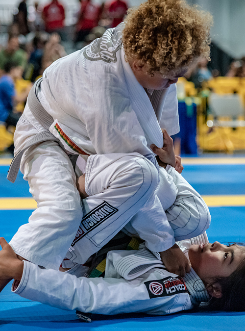 Kid applying a Brazilian Jiu-jitsu sweep on opponent at the IBJJF American National