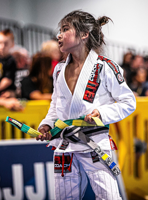 Young kid tying his belt at a Kid's Brazilian Jiu-jitsu tournament