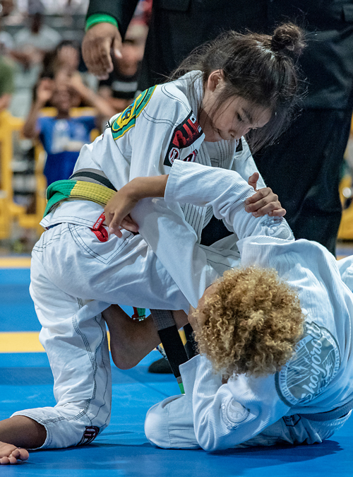 Kid's rolling against each other at Brazilian Jiu-jitsu tournament