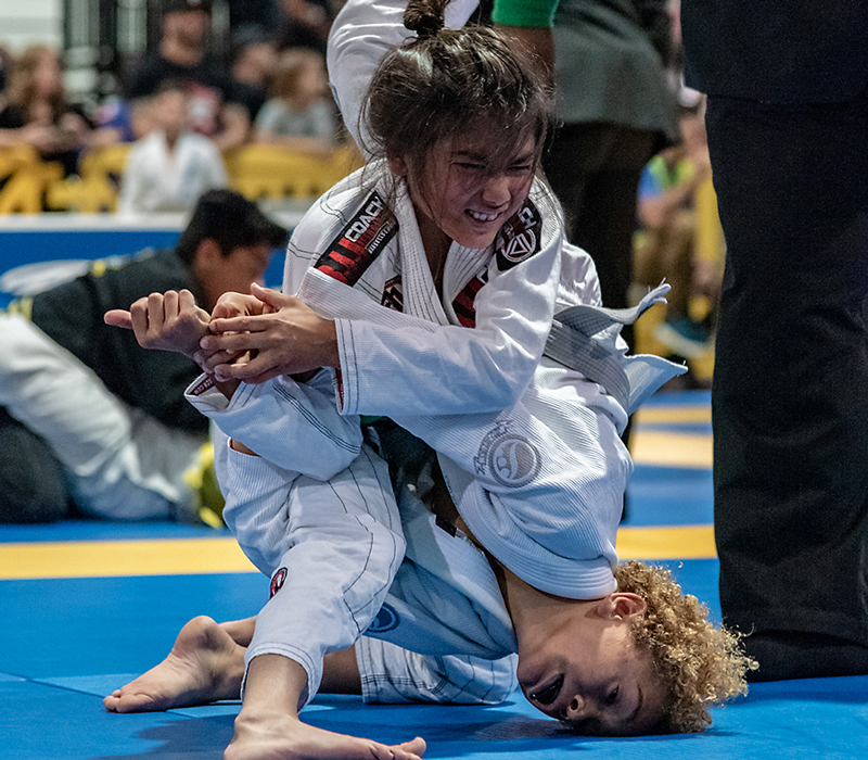 Kid defending a Brazilian Jiu-jitsu shoulder lock attempt at an IBJJF tournament