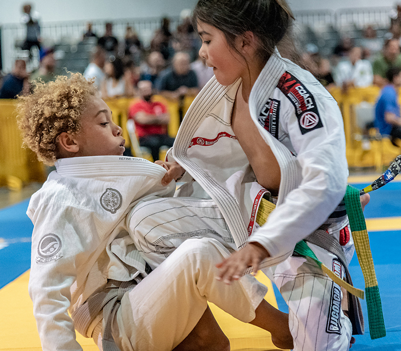 Kid BJJ martial artist passing the guard of an opponent